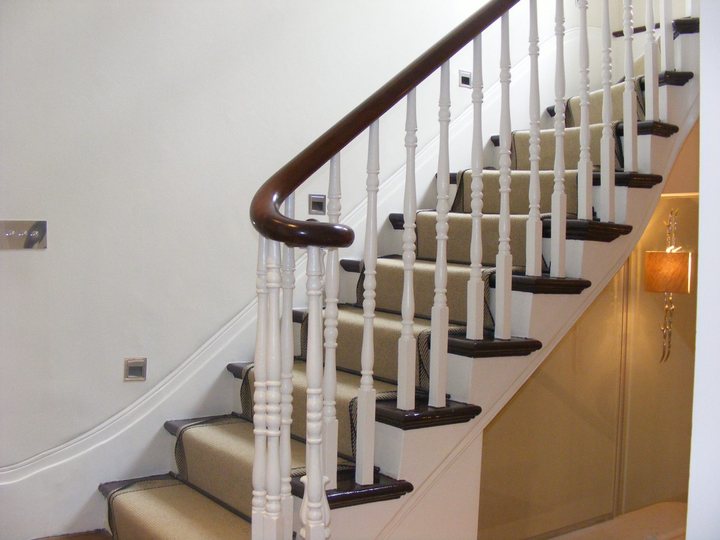 Painted staircase with dark handrail and light balustrades